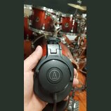 Černé uzavřené sluchátka s nápisem ATH-M30x a logem značky Audio-Technica v kruhu. Povrch plastu vykazuje drobné známky používání a lehké znečištění.…