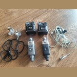 Na dřevěné podlaze leží sada bezdrátového systému Xvive. Sestává ze dvou černých přijímačů s nápisem Xvive U2 RECEIVER a dvou vysílačů, z nichž jeden…