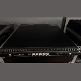 Černý rackový přístroj v transportním kufru s hliníkovými hranami. Na přední hraně je vidět ovládací panel s bílými tlačítky, USB portem a logy v pod…