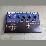 Černý efekt pedál s nápisy TONEBONE, Radial a TUBE DRIVE. Na horní části jsou pět kontrolních knoflíků s popisky LEVEL, HIGH, LOW, FILTER a DRIVE, tř…