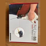 Fotografie znázorňuje krabici s bezdrátovým systémem pro kytaru. Na obalu je nápis Airline 88 Guitar Wireless System a logo SAMSON. V horní části je…