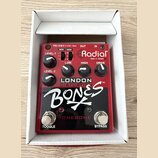 Červený kytarový efekt v bílém kartonovém boxu. Na zařízení jsou nápisy Radial Made in Canada, LONDON DISTORTION™, BONES a TONEBONE. Ovládání tvoří p…
