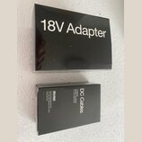Černá krabička s bílým nápisem 18V Adapter. Vedle ní je menší černá krabička s bílým nápisem DC Cables a textem Dunlop Manufacturing, Inc. P.O. Box 6…