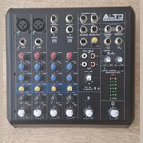 Šedý mixážní pult značky ALTO PROFESSIONAL. Na panelu jsou čtyři vstupní kanály označené CH1 až CH4, sekce BLUETOOTH a MAIN OUT. Jsou zde viditelné n…