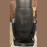 Černý svítící přístroj s matným povrchem a ventilačními mřížkami. Na spodní části korpusu je bílý nápis ROBE. Zařízení vykazuje mírné opotřebení a pr…