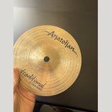 Zlatavý mosazný činel typu splash s viditelným rýhováním. Na povrchu je nápis „Anatolian“ v horní části a v dolní části text „traditional 6"/15cm Spl…