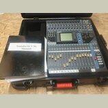 Digitální mixážní pult Yamaha 01V96 umístěný v černém transportním kufru. Zařízení má modrošedé provedení s řadou posuvníků, tlačítek a centrálním di…