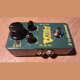 Zelený kytarový efekt s kovovým šasi a nápisy tc electronic, The Vibe Viscous. Na horní straně jsou tři černé oválové knoflíky s popisky VOLUME, INTE…