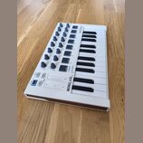 Bílá MIDI klaviatura s 25 klávesami a ovládacími prvky v horní části. Na přístroji je uveden nápis MINILAB mkII a značka ARTURIA. Obsahuje několik še…