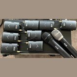 Sada devíti černých bezdrátových vysílačů s nápisem beyerdynamic a logem ve tvaru písmene V. Zařízení jsou umístěna na černém povrchu, z některých ve…