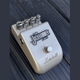 Kytarový efekt pedál stříbrné barvy s kovovým povrchem. Na horní straně je nápis THE JACKHAMMER JH-1 a ve spodní části logo Marshall. Zařízení má pět…