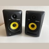 Dva černé studiové monitory s žlutými membránami basových reproduktorů. Na obou je vidět logo KRK a nápis ROKIT 5. Povrch krytů vykazuje drobné nečis…