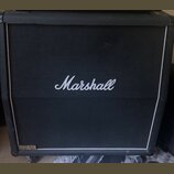 Černý kytarový reproduktor s bílým lemováním a černou textilní maskou. Uprostřed je umístěno bílé logo Marshall. V levém dolním rohu se nachází zlatý…