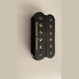 Černý humbucker snímač s dvěma řadami pólů. Na levém krytu je bílý nápis Seymour Duncan. Povrch vykazuje drobné škrábance a opotřebení, zejména u šro…