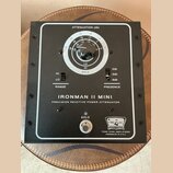 Černý přístroj s bílým rámečkem a nápisem IRONMAN II MINI PRECISION REACTIVE POWER ATTENUATOR. Obsahuje regulační knoflík s označením ATTENUATION (db…