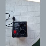 Černý plastový napájecí stabilizátor s dvěma zásuvkami a červeným vypínačem. Na zařízení je bílý nápis energenie a text MODEL: EG-AVR-0501, INPUT: 14…