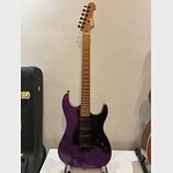 Fialová elektrická kytara s tmavým hmatníkem a černým pickguardem. Na hlavě je viditelné zlaté logo „Squier“. Tělo má lakovaný povrch s viditelnou st…