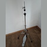 Stříbrný kovový stativ s černými plastovými prvky a tříramenou základnou. Na spodní části jedné z nožic je bílý plastový pedal s nápisem "Premier". P…