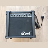 Černý kytarový kombo zesilovač značky Cort, model CM10G. Na horním ovládacím panelu jsou nápisy OVERDRIVE, EQUALISATION, POWER, INPUT, GAIN, VOLUME,…