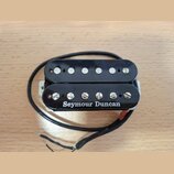 Černý humbucker s dvěma řadami šesti stříbrných pólů. Na spodní části je bílým písmem nápis Seymour Duncan. Snímač má připojený černý kabel a je umís…