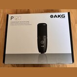 Fotografie znázorňuje krabici od kondenzátorového mikrofonu. Na bílém povrchu je nápis P120, CONDENSER MICROPHONE a text GENERAL PURPOSE RECORDING MI…