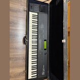Černý digitální klavír Roland XP-80 v černém transportním kufru. Na pravé straně je bílý nápis Roland XP-80 a text DIGITAL TON MODULE. Nástroj má bíl…