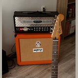 Kytarový zesilovač s nápisem MESA ENGINEERING a modelem DUAL Rectifier NOV WAVE umístěný na oranžovém kytarovém kombu značky ORANGE. Před přístroji s…