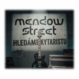 Černá elektrická kytara s tmavým hnedým hmatníkem a bílými značkami poloh. Na hlavě kytary je vidět nápis Epiphone. Kytara stojí před šedou stěnou s…