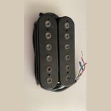 Dva černí elektrické snímače typu humbucker s viditelnými polosnovými póly. Povrch je černý, matný a vykazuje drobné škrábance a prach. Z pravého sní…