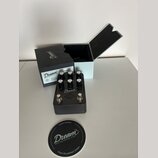 Šedý efekt pedál s nápisem Dream '65 REVERB-AMP. Na horní části jsou čtyři černé ovládací knoflíky s popisky DRIVE, TONE, VOLUME a REVERB, v dolní čá…