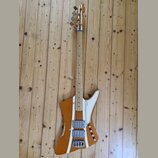 Elektrická basová kytara s hnědým trupem a hnedým krkem. Na hlavě je nápis "Squier". Trup má bílé dekorativní pruhy a dva snímače s kovovými kryty. P…