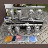 Čtyři stříbrné kovové reflektory jsou umístěny na horní liště a další čtyři na spodní liště černého transportního kufru. Všechny reflektory mají cyli…