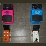 Čtyři efektové pedály v různých barvách. Růžový pedal má nápisy HEAVY DISTORTION, HD300 a logo behringer. Modrý pedal nese označení TUBE AMP MODELER,…