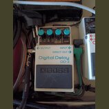 Kytarový efekt pedál Boss Digital Delay DD-3 v bílo-šedém provedení. Na horní části jsou čtyři modré ovládací knoflíky a nápisy CHECK, L 800ms HOLD,…