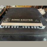 Rakový procesor s černým horním panelem a stříbrným předním panelem. Na horní části je bílý nápis SONIC EXCITER, pod ním text ULTIMATE STEREO SOUND E…