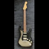 Elektrická kytara s černým bodies, hnědým hmatníkem a světle hnědou hlavou. Na hlavě je nápis Fender Stratocaster. Kytara má tři bílé snímače, tři bí…