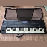 Černý digitální klavír Roland G-800 v černém polstrovaném pouzdře. Na levé straně je nápis Roland G-800 a pod ním text 64 VOICE POLYPHONY. Přístroj o…