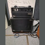 Černý kytarový kombozesilovač složený z komba a hlavního zesilovače. Na obou částech jsou vidět loga Kustom a nápisy Deep End. Přední panel zesilovač…