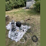 Sada zvukové techniky rozložená na bílé plátno s květinovým vzorem na trávníku. Soubor obsahuje dva šedé reproduktory, černý mixovací pult, mikrofonn…