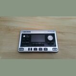 Stříbrný digitální rekordér s nápisy BOSS a MICRO BR DIGITAL RECORDER BR-80. Zařízení má černé ovládací prvky, displej a tlačítka s označením MENU, A…