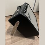 Černý kytarový kombo zesilovač s bílou textilní maskou a kovovými prvky. Na horním ovládacím panelu je nápis STRATOCASTER a logo Fender. Zesilovač má…
