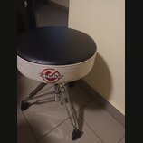 Fotografie zobrazuje bubenícký stolec s kulatým černým sedákem a bílým bočním okrajem. Na boku je červeně a černě vyvedené logo s nápisem Gibraltar.…