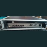 Černý basový zesilovač Ampeg B2R umístěný v hliníkovém transportním kufru. Na předním panelu jsou ovládací prvky s nápisy INPUT, PAD, GAIN, BASS, ULT…