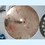 Kruhový činel z bronzu s viditelným klepaným povrchem a patinou. Na povrchu je červený nápis WILD RIDE 20" a červené logo s textem Twistel, 2002, MAD…