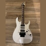 Bílá elektrická kytara s perleťovým pickguardem a hnědým hmatníkem. Na hlavě je viditelné logo Jackson. Nástroj má tři humbuckery, jeden ovládací kno…