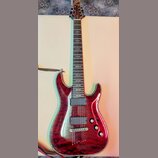 Elektrická kytara s červeným lakovaným tělem s výraznou strukturou dřeva a lemováním. Na hlavě je nápis Schecter. Nástroj má dva humbuckery, tři ovál…