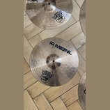 Fotografie zobrazuje dva kovové činely v tradičním zlatavě hnědém odstínu s viditelným rýhováním. Na spodním činele je nápis MEINL a logo značky, dál…
