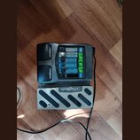 Černý kytarový procesor značky Digitech s připojeným externím pedálem. Na přístroji je vidět nápis Digitech, označení BYPASS a zelený displej s texte…
