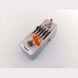 Stříbrný efekt pedál s oranžovým grafickým motivem. Na horní straně je nápis GT EQ, ovládací knoflík VOLUME a pět posuvníků s označením frekvencí 100…
