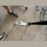 Kovový pedál basového bubnu stříbrné barvy s černým logem znázorňujícím stylizované písmeno A a lebku. Na levém okrave je malý nápis "Rd". Povrch ped…